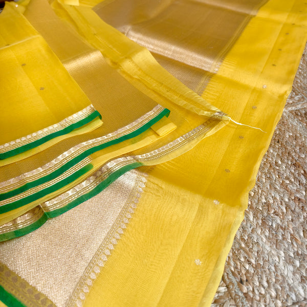 Vibrant yellow silk organza saree with bottle green small borders