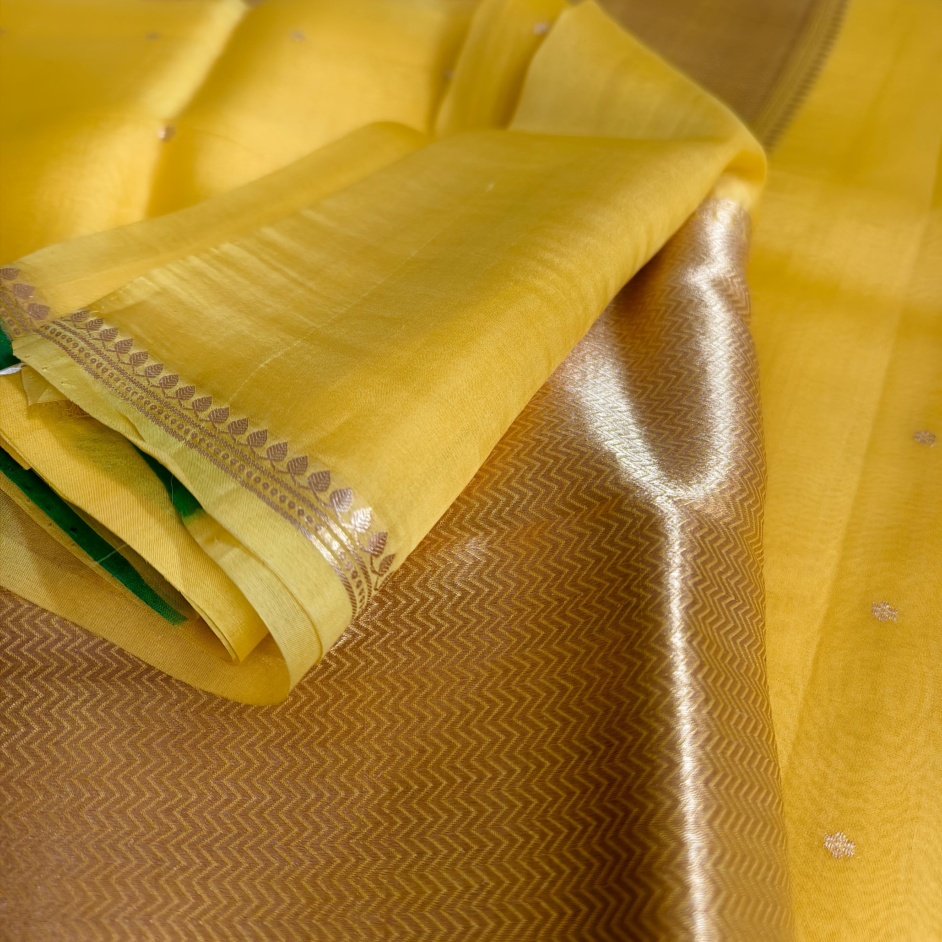 Vibrant yellow silk organza saree with bottle green small borders